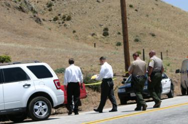 L.A. County Sheriff?s homicide investigators arrive at the scene where commuting mountain residents reported glimpsing a man at the side of the road Tuesday, May 20 on Gorman Post Road. 







