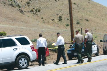 L.A. County Sheriff?s homicide investigators arrive at the scene where commuting mountain residents reported glimpsing a man at the side of the road Tuesday, May 20 on Gorman Post Road. 


