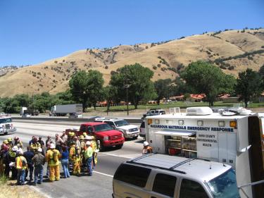 Kern County Fire Department officials brief emergency personnel prior to having hazardous materials crews move in to assess the chemical spill on Interstate 5. El Tejon School is across the freeway. [Meyer photo]







