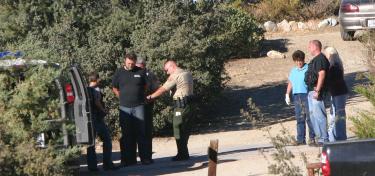 Lockwood Valley horse owners Ernie Bor (left, in black shirt) and Joan Bor (far right) are taken into custody by Ventura County Sheriff's deputies at the Bors' Cochema Ranch, Wednesday morning. [Photos by Gary Meyer, The Mountain Enterprise]




























