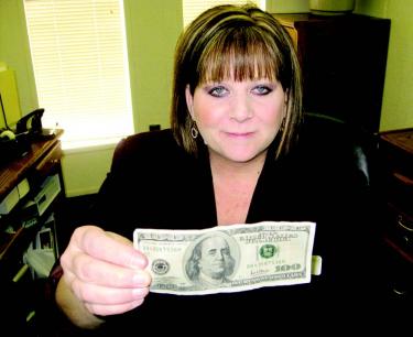 Antelope Valley Bank Branch Manager Kelli Strahl holds a fake $100 bill. Could you tell it apart from a real one?
