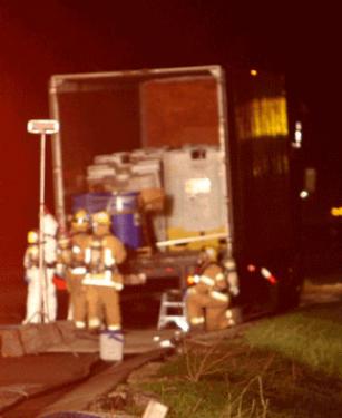 Kern County firefighters and Hazmat team members examine a truck where chemicals were found to be leaking after a fire broke out in the big rig's rear wheels on Tuesday evening, March 3, about two miles north of El Tejon School.



