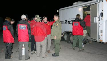 Ventura County Sheriff's Sr. Deputy Ryan Clark with Fillmore Search and Rescue team members at the command center below the Mt. Pinos summit, Sunday night. [Photo by Katy Penland]






