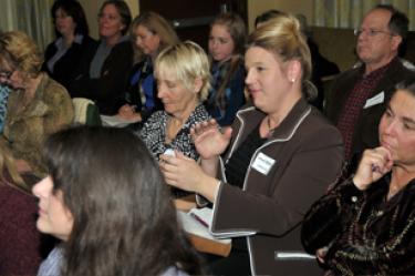 Moxie McMahon (in brown) asks a question at the Synergy Summit Business Conference February 11. To her left is Laura Olney, of Traffic Zone. In front is Rachel Unell of GrantGopher.com and Accounting for Success. About 65 business owners attended.
