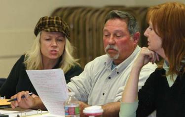MAC members (l-r) Stacey Havener, Steve Newman and Anne Weber discuss the drafting of a motion to write a letter to Supervisor Ray Watson informing him of the community’s concerns over Frazier Park Estates. Watson was among those looking on.
