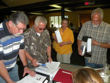 Victorious slate of reform candidates (l-r) William Martin, Gary Biggerstaff, Kim Wickers and Michael Joseph collect their notebooks of study materials for their new positions as members of the Pine Mountain Club Property Association board of directors.