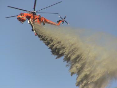 A Sikorsky Sky-Crane tanker drops muddy water on the Base fire, east of Interstate 5 Sunday, Aug. 22. [photo by The Mountain Enterprise]