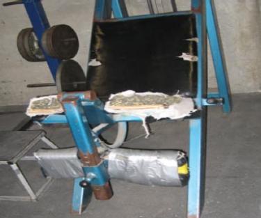 At the high school, previous, the upholstery on the weight bench is shredded and, above, the weight machines are held together with  duct tape in a dim workout room.
