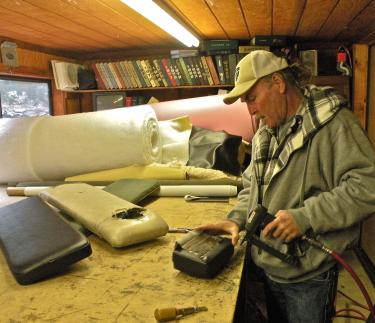 Ralph Wernli in his Pine Mountain Upholstery workshop, carefully fixing the weight bench cushions for Frazier Mountain High School. Wernli said he hopes students enjoy the equipment and use it with respect.