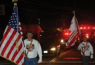 VFW Post 9791 carried the flags with Grand Marshal Captain Christopher Stroub just behind, leading a glowing army of firefighters and emergency vehicles brightening up the night for the Fantasy of Lights Parade.