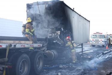 Firefighters work to put out the fire that engulfed the cab of the truck carrying metal pipes. It rammed into the back of a big rig carrying wood chips at about 1:20 p.m. Thursday, Jan. 6. Pipes scattered across the road, delaying access by firefighters and ambulance crews. Here the Kern County Fire Department finishes putting out the blaze. You can see some of the pipe on the road that were being carried by Freer's rig.