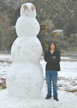 Six-foot Ivan Chavez from Santa Clarita stands next to Frosty, an 11-foot ambassador of fun built by snow play visitors in Frazier Mountain Park last weekend. [Mountain Enterprise photo / by Pam Sturdevant]