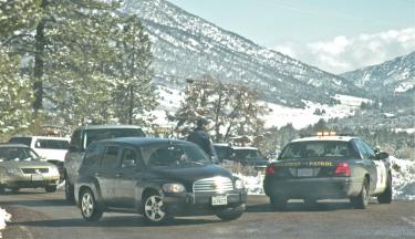 When the slopes surrounding the Mountain Communities are dusted with snow, visitors from Santa Barbara, Los Angeles and Bakersfield come to enjoy family fun. California Highway Patrol officers are on hand to keep traffic conditions safe. Here, officers check cars for chains and inform drivers about safe parking requirements on Mount Pinos, where all vehicles parked along the roadway must face downhill.[Hedlund Photo/The Mountain Enterprise]