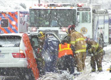 Kern County Fire Department and Hall Ambulance paramedic crews attempt to free vehicle passengers who are stuck inside a BMW station wagon on Frazier Mountain Park Road near Grand Terrace Estates. [Mountain Enterprise photo]