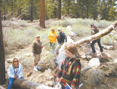 As this photo was being taken on the family's hike on Mount Pinos, a faint voice was heard. The missing woman was found down a ravine, dug into a burrow in the dirt beneath a log. She was injured and dehydrated, with no food or water for three days.