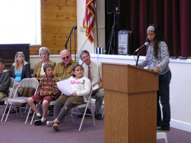 Back row: board Members Patty Edwards, Julie Ralphs, Steve Sonder and Principal Martin Schmidt; (front) student readers Louis Patterson (3rd grade) and Emily Chavez (1st grade) look on as 5th grader Marissa Beale reads a poem at the dedication ceremony.