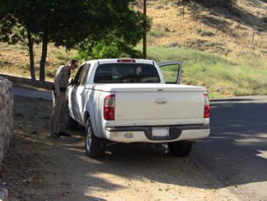 Only a block away, on Circle Drive, the hit and run suspect's truck is examined while the suspect receives medical attention for injuries possibly sustained in the collision. [photo by The Mountain Enterprise]
