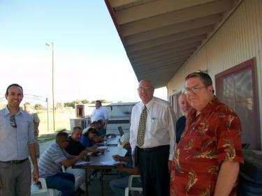 In the background, residents of the Antelope Acres area filled out applications for construction-related jobs for the First Solar AV Solar Ranch One on July 20. It will be a 2,093-acre solar utility. First Solar will also build the NRG solar project. Standing in the foreground (l-r) are Alex Martin (with the community relations team for First Solar), Norm Hickling (5th District Field Deputy for L.A. County Supervisor Michael Antonovich) and Karl Humphreys, who has argued strenuously for concessions from the company to benefit the surrounding communities. He and others in the rural town councils argue that they will be forced to watch the rural landscapes around them be transformed by highly-subsidized green energy developers. They say if they cannot stop these changes, communities deserve to benefit and mitigations need to be in place.