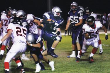 Falcon Patrick Moulder (center) breaks through the line with the ball in the September 30 game against the Grace Brethren Lancers of Simi Valley.