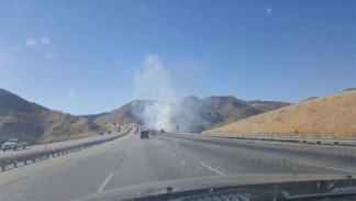 A grass fire burns on the northbound side of Interstate 5 at about 4:45 p.m. on Thursday, July 21. [photo by Beth Worrell]