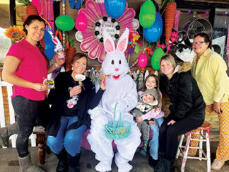 Right (l-r): Gathered on the front patio of our local cookie factory, Paula Regan and her mom Donna Crow, co-owners of Crow’s Custom Cookies; the Easter Bunny; Natalie and Jackson with their mom Katie Mattern of Mountain Paws Pet Grooming; and helper Lori Potter.