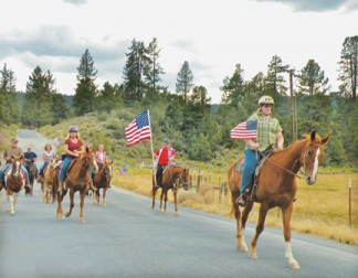 The Ride to Remember in Cuddy Valley is entering its 14th year, shown here led by Emily (front) and Militsa Brennan (with the large flag). [photo by Patric Hedlund]