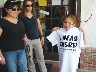 (l-r) Ruth Terrell and Christy Gomez with Emily Gomez at Caveman Cavey’s showing off the t-shirt given to all participants. [June Schmidt photo]