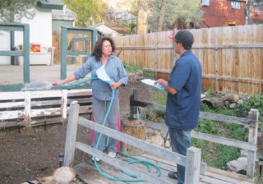 Otilia Herrera was watering her plants when Rafael Molina, Jr. handed her an emergency water conservation notice on Tuesday evening. Molina went door to door alerting the community on behalf of the water company.
