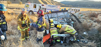 Kern County and Los Angeles fire captains discuss an accident scene two weeks ago on November 28 as their firefighters work to extricate a FedEx truck driver from his cab at the overcrossing on the Lebec curve. The driver suffered major injuries.