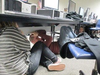 Students in Mrs. Heasley's journalism class at FMHS immediately took cover under their desks as the alarm sounded at 10:17 a.m. on Thursday, Oct. 17. [photo by Gary Meyer]