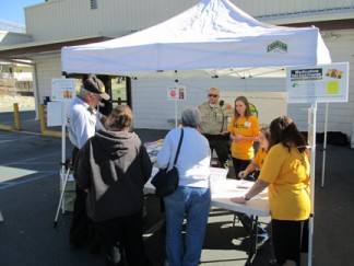 (l-r) Sheriff's Volunteers Mike Hall and Carol Trudeau, Kern County Sheriff's Sergeant Mark Brown, and MCCASA volunteers Tina Fessia, Marie Marot and Lisa Walter assist local residents to turn in their medications for disposal. [photo by Gary Meyer]
