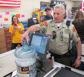 McCASA’s Tina Fessia watches Sgt. Mark Brown weigh over 6,300 pills. [photo by Gary Meyer]