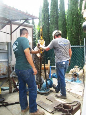 Contractor CJ Logan's supervisor John May (right) and his crew place the discharge assembly on the well, just before connecting it to the Krista Mutual Water Company main lines on Monday, Sept. 8. Water Operator Rafael Molina, Jr. (left) observes. [photo by Gary Meyer]