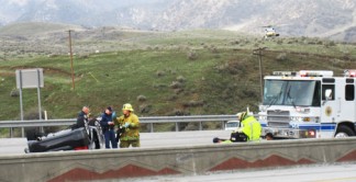 Emergency crews tend to the injured while a CHP officer inspects the passenger vehicle. [photo by Gary Meyer, The Mountain Enterprise]