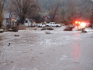 Homes along this overflowing creek have been evacuated in Lake of the Woods. [photo by Gary Meyer, The Mountain Enterprise]