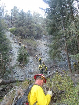 The long hard slog up a very steep wall out of a ravine. The fire was burning just over the ridge top. [photo by Gary Meyer]