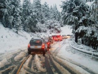 Snow snarled traffic on Mil Potrero Highway as drivers waited for a fender-bender to be cleared just west of the ‘Y’ on Friday morning, Dec. 12. [photo by Gary Meyer]