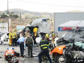 Right: Emergency crews try to save the lives of the drivers of both vehicles after an ambulance was stolen and crashed into a big-rig truck in front of the Flying J truck stop in Lebec. [photo by Gary Meyer]