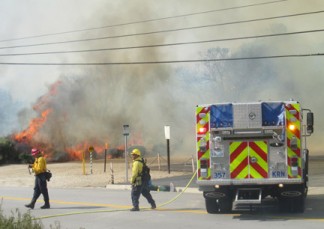 Flames climb high as Kern County firefighters try to hold the fire to the field on the north side of Lebec Post Office. [photo by Gary Meyer]