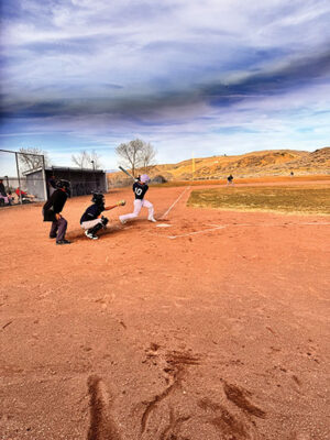 Baseball player hitting the ball into left field