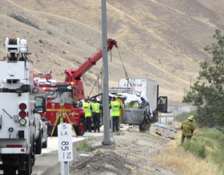 One of several vehicles involved in Tuesday morning's fatal crash is hoisted up from the side of Interstate 5. [photo by Gary Meyer, The Mountain Enterprise]