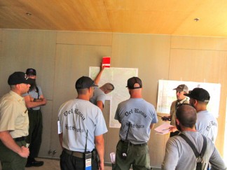 Incident Commander Trainee Peter Stephenson briefs members of the Del Rosa Hotshots on basics of the fire. [photo by Gary Meyer, The Mountain Enterprise]
