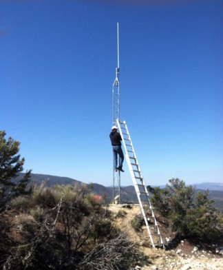 Dan Wilson climbs the tower to secure it and the antenna to a retractable ladder [photo by Mike Cram]