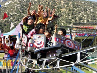Fiesta Days-goers scream along the roller coaster in earlier years of the festival. [photo by Gary Meyer]